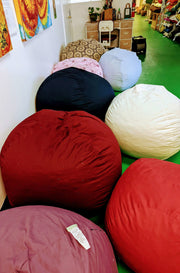 White Lotus kapok bean bags in a variety of colors sit on the floor of an office space.
